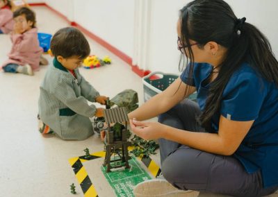 Niño y educadora en área de construcción